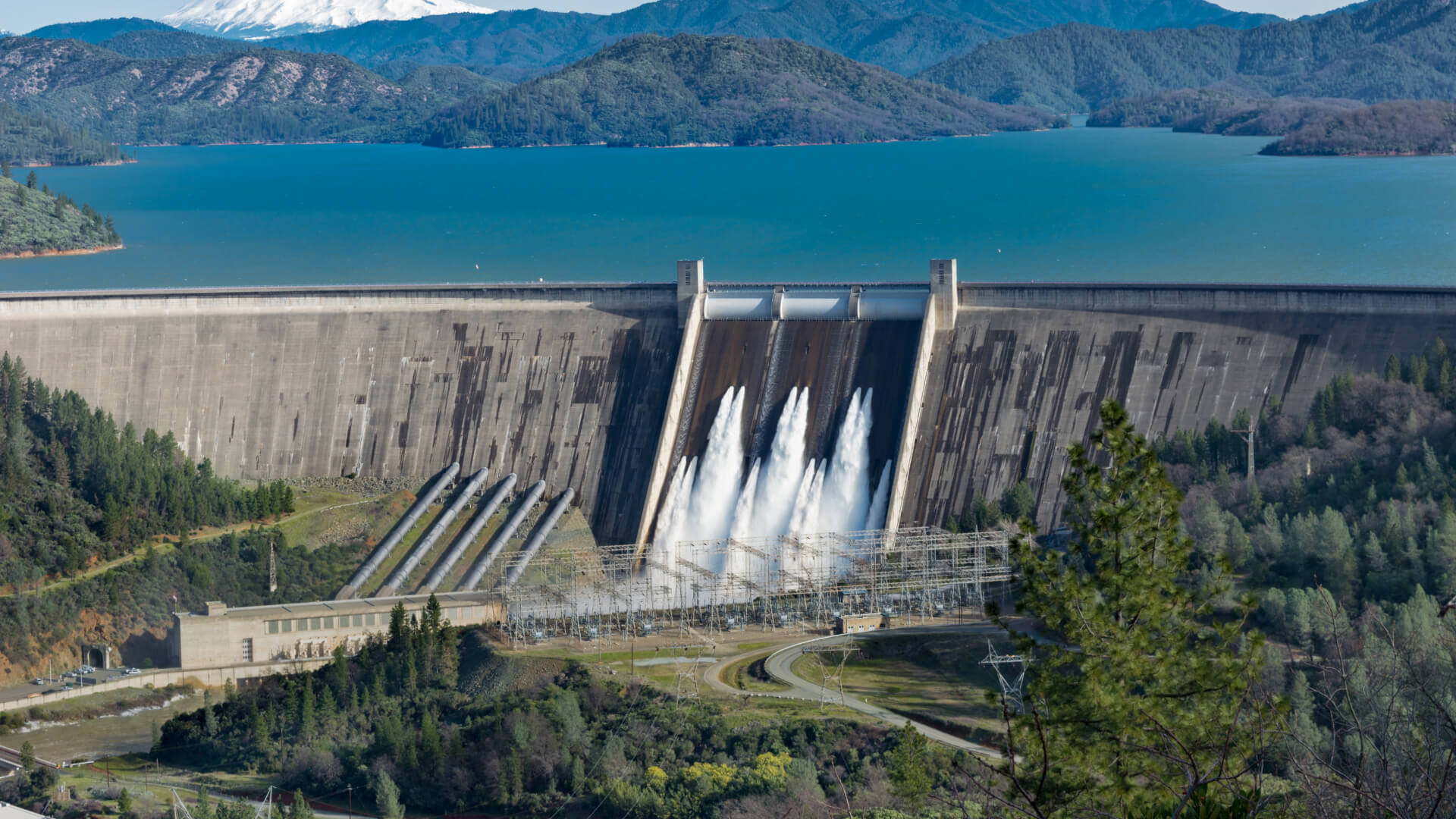 picture-shasta-dam-surrounded-by-roads-trees-with-lake-mountains